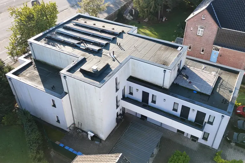 Drohnenaufnahme des Studentenwohnheims in Lippstadt vor der Fassadenreinigung mit grau-grünem Belag auf der Fassade